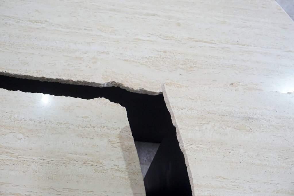 割れてしまったトラバーチンの天板。割れるという物語を継承しセンターテーブルに。土台部分はスチールの黒染め塗装仕上げ。天板