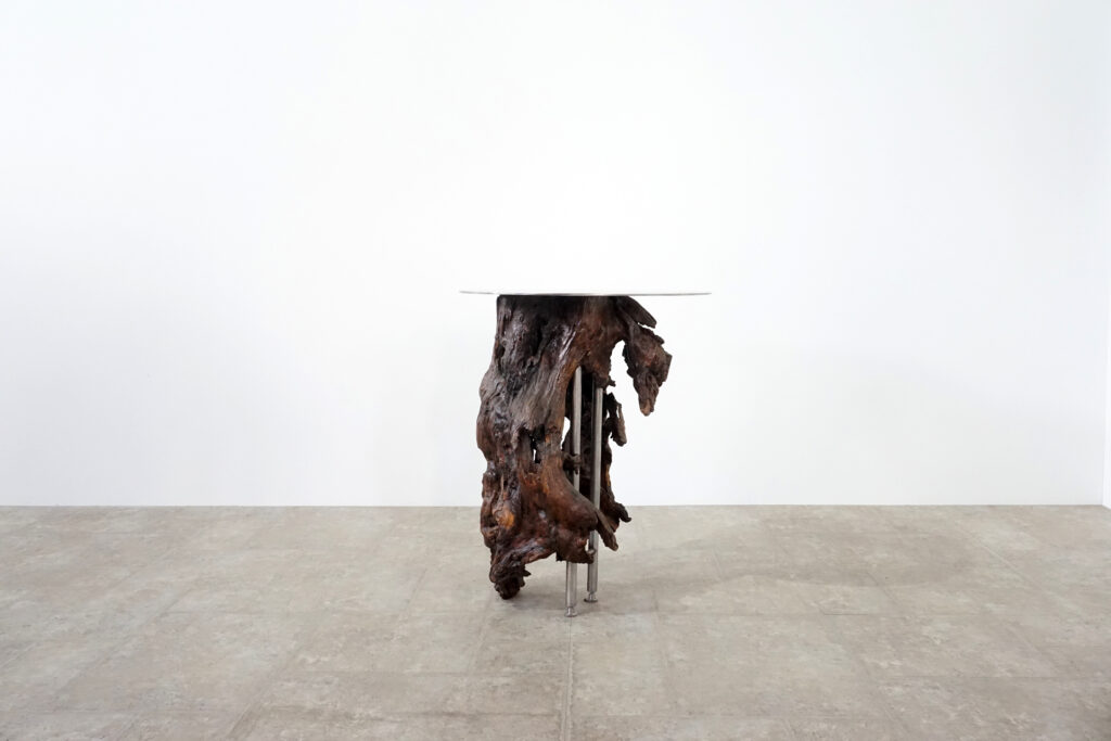 インテリアアクセントとして使われてきた流木をステンレス天板を交えてサイドテーブルへカスタム。流木の流動的で自然な風合いと、ステンレスのインダストリアルモダン感のコントラストが際立つものに仕上がりました。天板はステンレス板をランダムに荒らしたサンディング仕上げ。右斜め