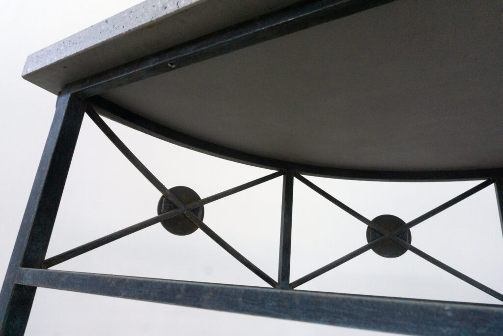 1890年代フランス製の鍛鉄コンソール。オリジナルはガラス天板ですが、紛失のため、天然石をモールテックスで包んで仕上げたビールストーン天板にカスタム。緑青がかった鍛鉄は足元がテーパー、ボールになっており丹念に制作されています。また、アール・ヌーヴォーの影響も垣間見れる花模様のブロンズパーツも魅力的です。天板裏