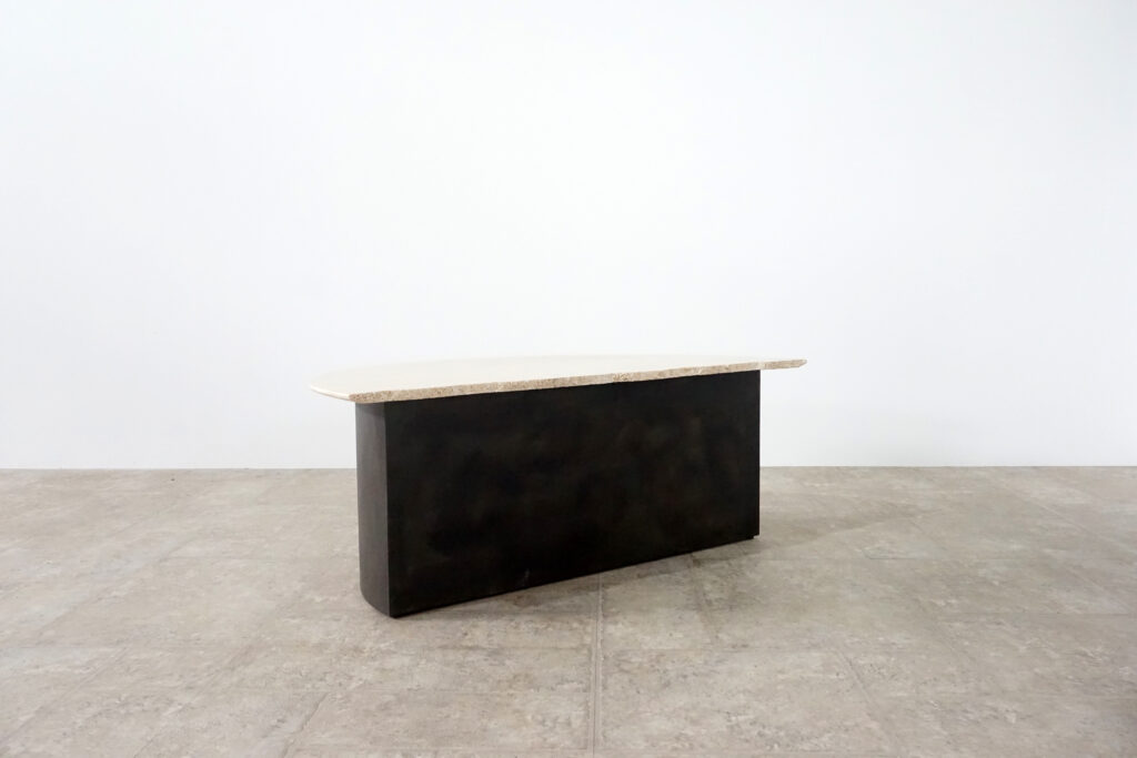 割れてしまったトラバーチンの天板。割れるという物語を継承しセンターテーブルに。土台部分はスチールの黒染め塗装仕上げ。1:2ななめ