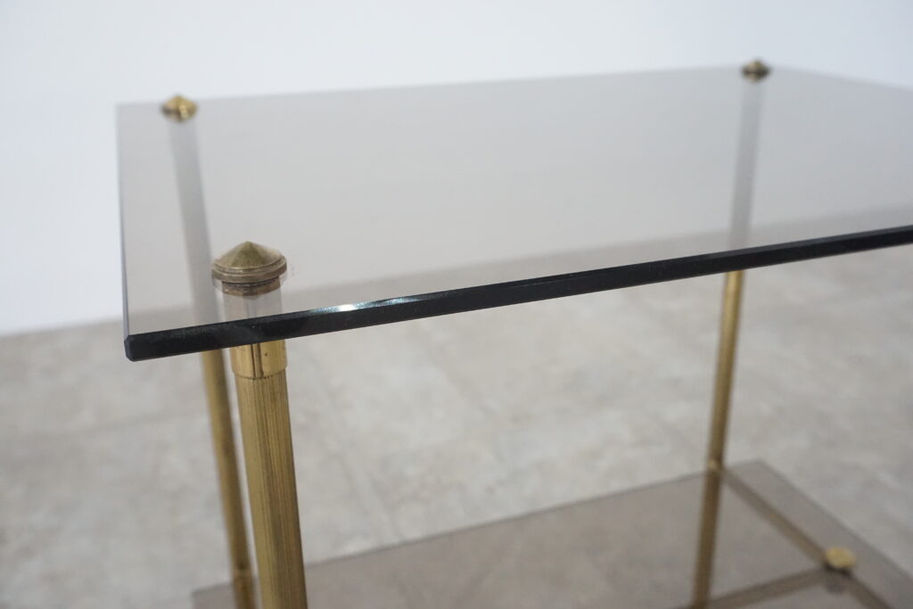 1960年代の真鍮製ヴィンテージサイドテーブル。ガラス天板はブロンズ色ガラスで新規製作。テーパーのついた脚が特徴的です。天板斜め