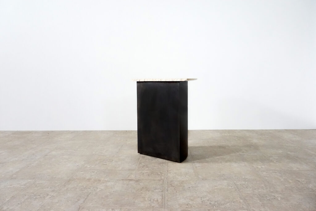 割れてしまったトラバーチンの天板。割れるという物語を継承しセンターテーブルに。土台部分はスチールの黒染め塗装仕上げ。3:10横