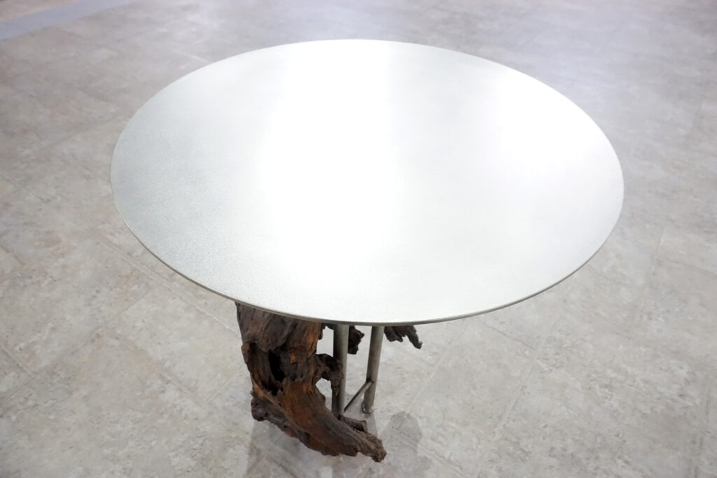 インテリアアクセントとして使われてきた流木をステンレス天板を交えてサイドテーブルへカスタム。流木の流動的で自然な風合いと、ステンレスのインダストリアルモダン感のコントラストが際立つものに仕上がりました。天板はステンレス板をランダムに荒らしたサンディング仕上げ。天板上部