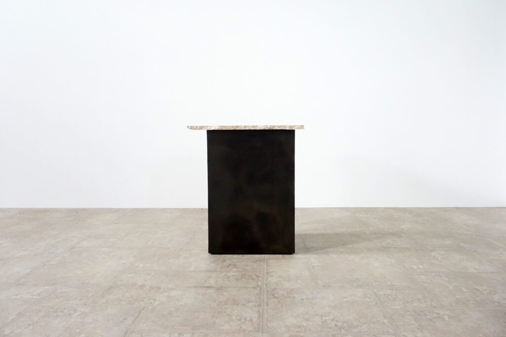 割れてしまったトラバーチンの天板。割れるという物語を継承しセンターテーブルに。土台部分はスチールの黒染め塗装仕上げ。3:10真横