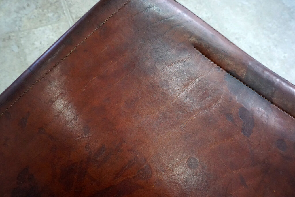 1970年代イタリア人デザイナー カルロ・バルトリ（Carlo Bartoli）によってデザインされたダイニングチェア。背もたれのアルミパーツが破損の為、より強度のあるスチール（黒クロームメッキ）を製作。深みのあるエイジングレザーと、滑らかにカーブする金属フレーム。クラシックとモダンが絶妙に交わる、スタイリッシュなダイニングチェア。座面寄り