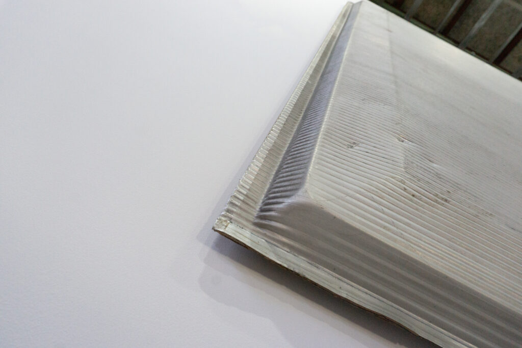 Jean Prouveが設計に携わった、フランス、リヨンにあるINSA(Institut National des Sciences Appliquees)において、建材として使用されていたパネル。プレス機によるエンボス加工が施された、アルミ素材のパネルになります。左下見上げ