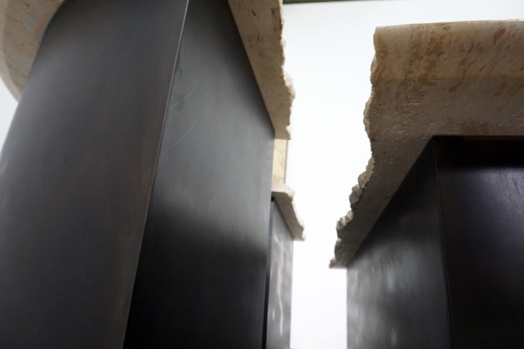 割れてしまったトラバーチンの天板。割れるという物語を継承しセンターテーブルに。土台部分はスチールの黒染め塗装仕上げ。下