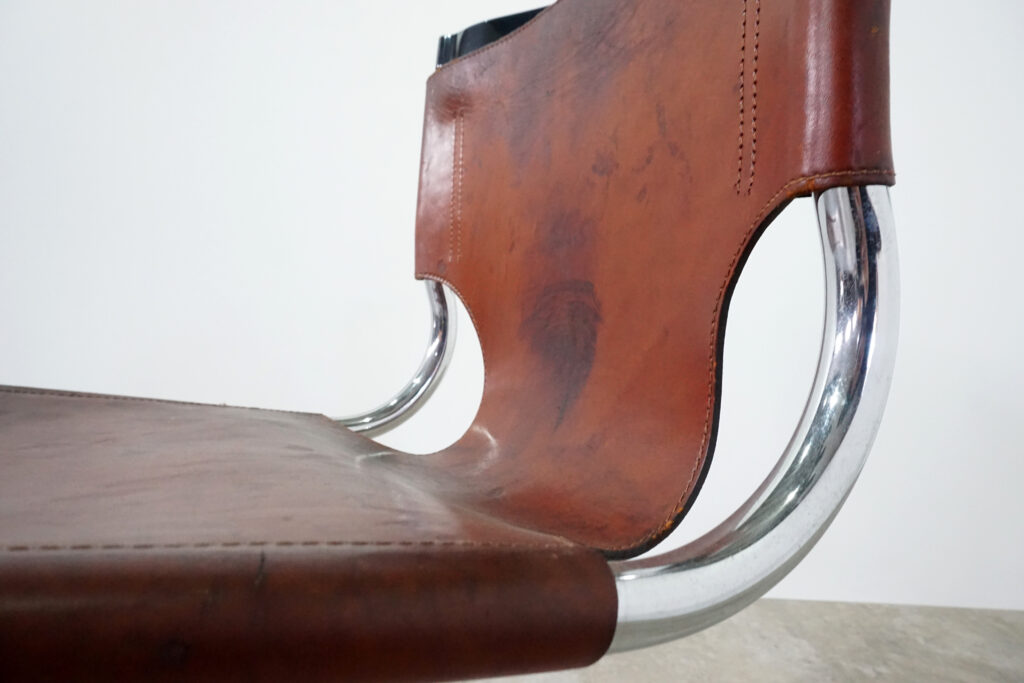 1970年代イタリア人デザイナー カルロ・バルトリ（Carlo Bartoli）によってデザインされたダイニングチェア。背もたれのアルミパーツが破損の為、より強度のあるスチール（黒クロームメッキ）を製作。深みのあるエイジングレザーと、滑らかにカーブする金属フレーム。クラシックとモダンが絶妙に交わる、スタイリッシュなダイニングチェア。座面境界寄り