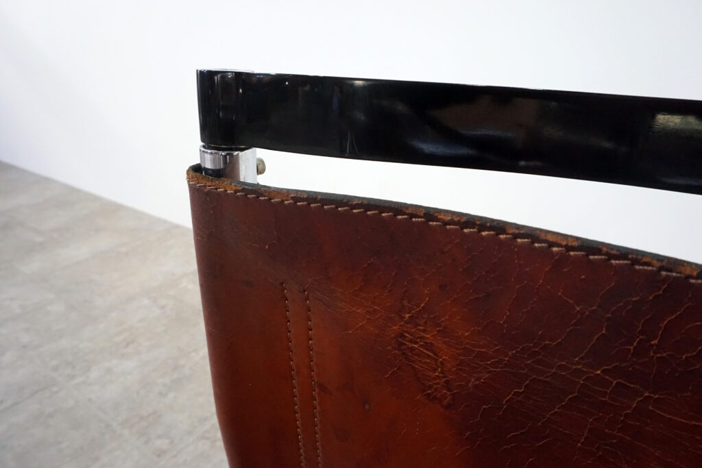 1970年代イタリア人デザイナー カルロ・バルトリ（Carlo Bartoli）によってデザインされたダイニングチェア。背もたれのアルミパーツが破損の為、より強度のあるスチール（黒クロームメッキ）を製作。深みのあるエイジングレザーと、滑らかにカーブする金属フレーム。クラシックとモダンが絶妙に交わる、スタイリッシュなダイニングチェア。座面左前