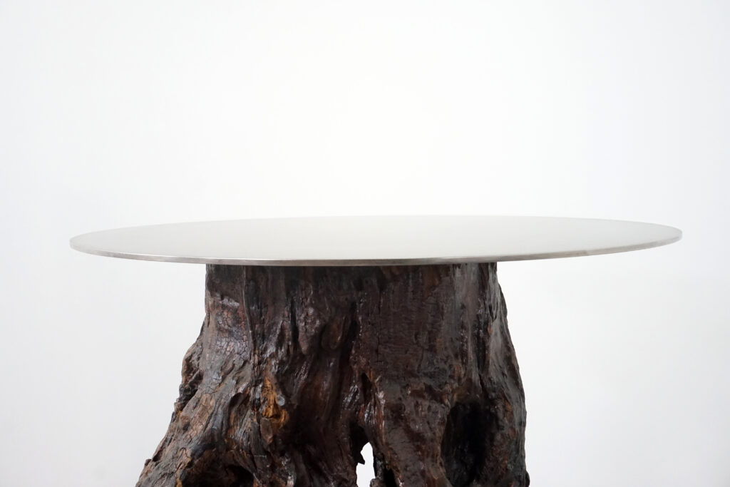 インテリアアクセントとして使われてきた流木をステンレス天板を交えてサイドテーブルへカスタム。流木の流動的で自然な風合いと、ステンレスのインダストリアルモダン感のコントラストが際立つものに仕上がりました。天板はステンレス板をランダムに荒らしたサンディング仕上げ。天板正面