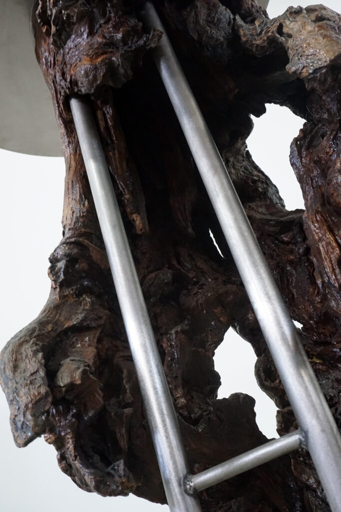 インテリアアクセントとして使われてきた流木をステンレス天板を交えてサイドテーブルへカスタム。流木の流動的で自然な風合いと、ステンレスのインダストリアルモダン感のコントラストが際立つものに仕上がりました。天板はステンレス板をランダムに荒らしたサンディング仕上げ。足見上げ