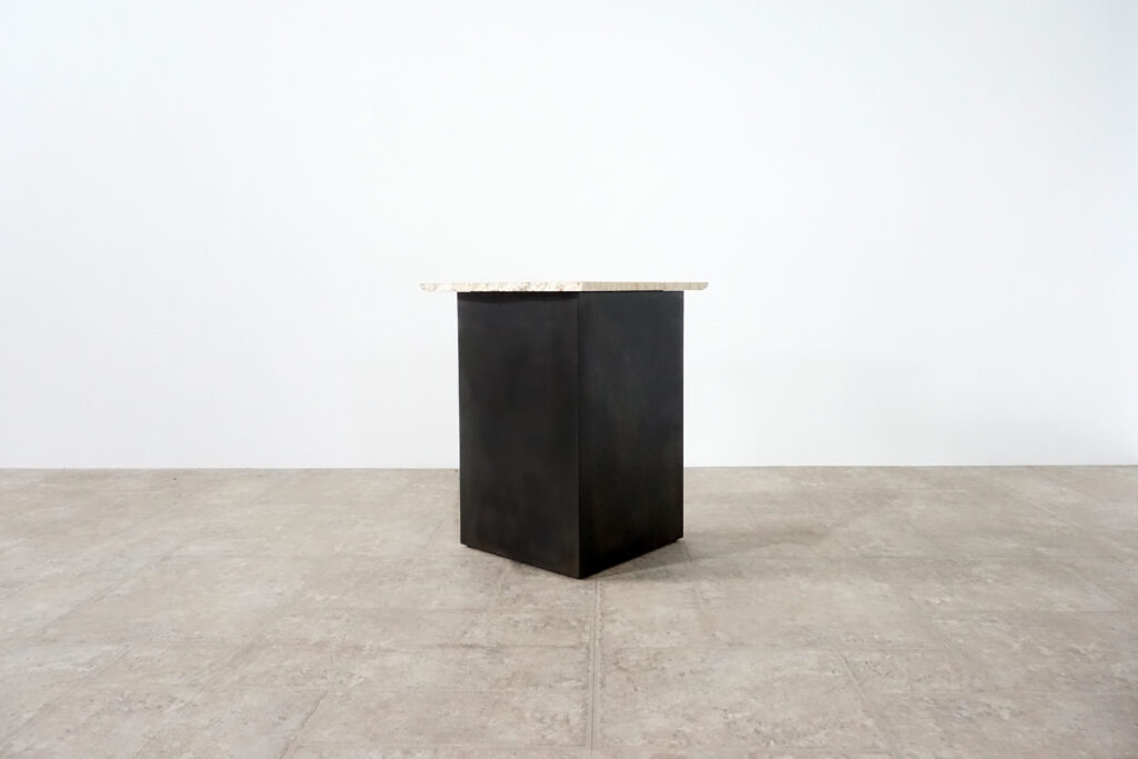 割れてしまったトラバーチンの天板。割れるという物語を継承しセンターテーブルに。土台部分はスチールの黒染め塗装仕上げ。3:10ななめ