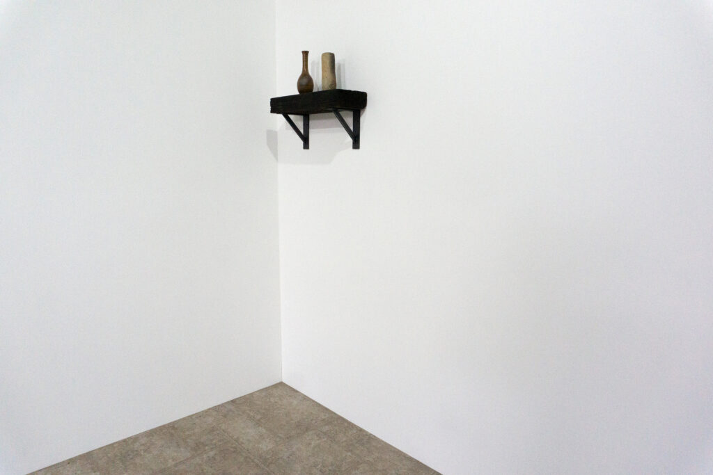 古材の梁から切り出した厚みのある木塊を、そのまま棚として再構成したウォールシェルフ。時間を刻んだ木材の質感と重量感を活かし、壁面から静かに突き出すような存在感をつくります。棚受けには、鉄の黒皮材を用いたオリジナルブラケットを新規制作。素材の表情を残した黒皮鉄を黒塗装で仕上げ、古材の力強さと調和するシンプルな構造としています。古材が持つ個体差や痕跡をそのまま活かしながら、現代の空間に静かな緊張感を与えるプロダクトです。角引き