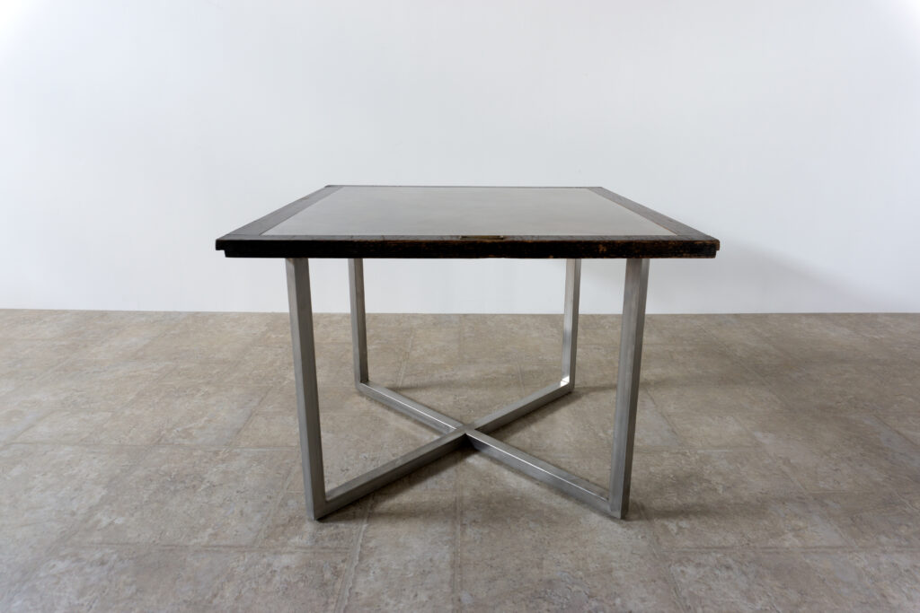 古い木製扉を再利用したテーブル。既存の木枠はそのまま活かし、中央にはステンレス板をフラットに納めています。天板は段差を抑えた構成で、実用性と意匠性を両立。脚部にはステンレス角パイプを使用し、十分な強度と安定性を確保。木部の経年変化とステンレスの均質な質感が対比され、空間に適度な緊張感を与える。一点ごとに表情の異なる木枠を使用しているため、同一仕様でも個体差があります。住宅空間から店舗什器まで幅広く使用可能。Threshold / Plane 01横上