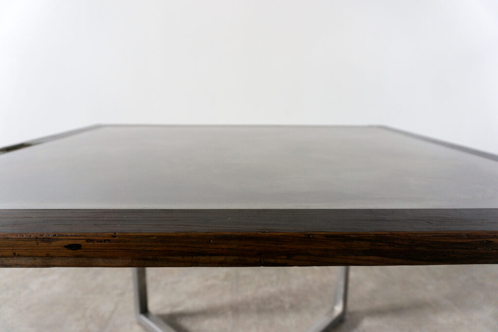 古い木製扉を再利用したテーブル。既存の木枠はそのまま活かし、中央にはステンレス板をフラットに納めています。天板は段差を抑えた構成で、実用性と意匠性を両立。脚部にはステンレス角パイプを使用し、十分な強度と安定性を確保。木部の経年変化とステンレスの均質な質感が対比され、空間に適度な緊張感を与える。一点ごとに表情の異なる木枠を使用しているため、同一仕様でも個体差があります。住宅空間から店舗什器まで幅広く使用可能。Threshold / Plane 01天板寄り