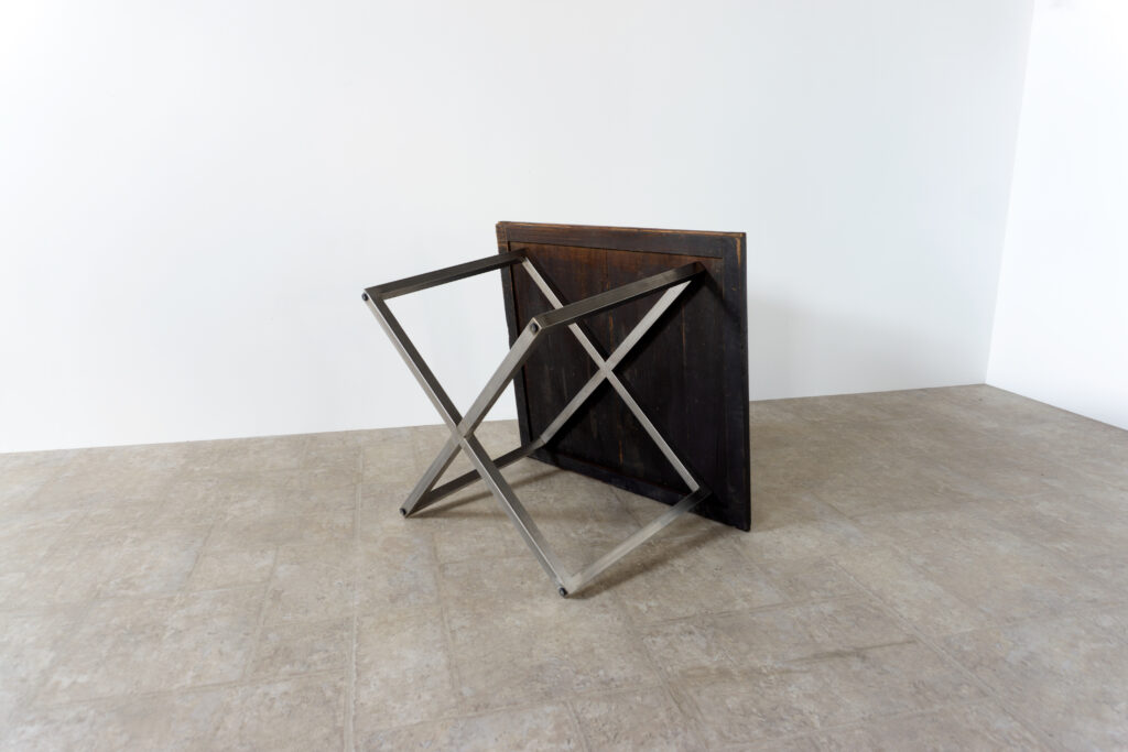 古い木製扉を再利用したテーブル。既存の木枠はそのまま活かし、中央にはステンレス板をフラットに納めています。天板は段差を抑えた構成で、実用性と意匠性を両立。脚部にはステンレス角パイプを使用し、十分な強度と安定性を確保。木部の経年変化とステンレスの均質な質感が対比され、空間に適度な緊張感を与える。一点ごとに表情の異なる木枠を使用しているため、同一仕様でも個体差があります。住宅空間から店舗什器まで幅広く使用可能。Threshold / Plane 01底面