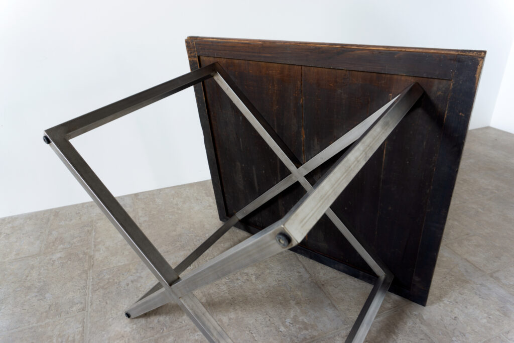 古い木製扉を再利用したテーブル。既存の木枠はそのまま活かし、中央にはステンレス板をフラットに納めています。天板は段差を抑えた構成で、実用性と意匠性を両立。脚部にはステンレス角パイプを使用し、十分な強度と安定性を確保。木部の経年変化とステンレスの均質な質感が対比され、空間に適度な緊張感を与える。一点ごとに表情の異なる木枠を使用しているため、同一仕様でも個体差があります。住宅空間から店舗什器まで幅広く使用可能。Threshold / Plane 01底面寄り