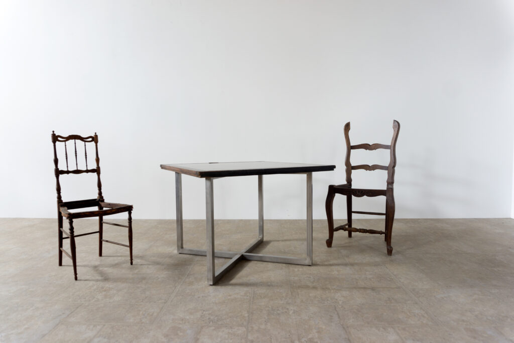 古い木製扉を再利用したテーブル。既存の木枠はそのまま活かし、中央にはステンレス板をフラットに納めています。天板は段差を抑えた構成で、実用性と意匠性を両立。脚部にはステンレス角パイプを使用し、十分な強度と安定性を確保。木部の経年変化とステンレスの均質な質感が対比され、空間に適度な緊張感を与える。一点ごとに表情の異なる木枠を使用しているため、同一仕様でも個体差があります。住宅空間から店舗什器まで幅広く使用可能。Threshold / Plane 01椅子2脚